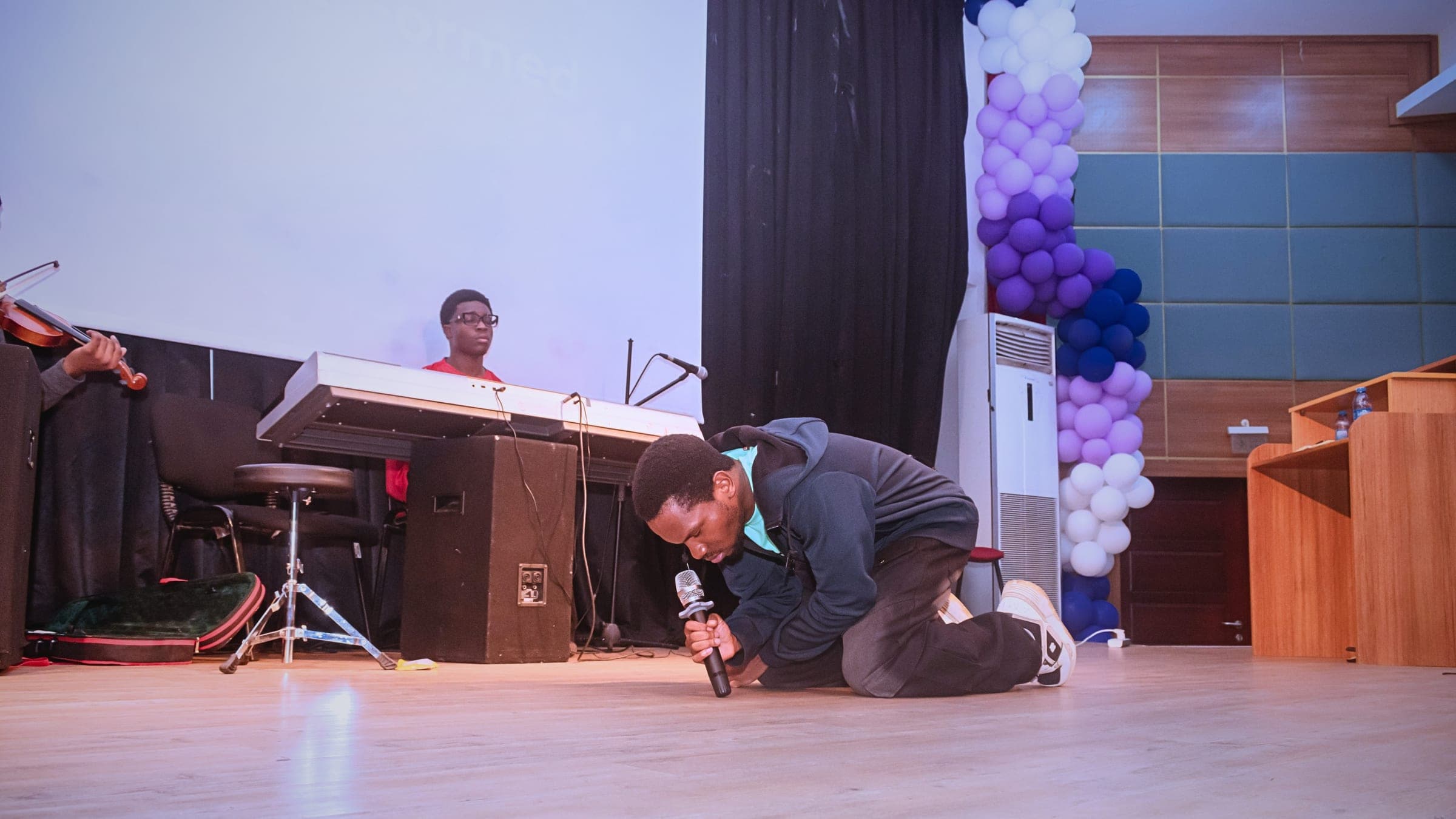 A student leading worship on keyboard during a fellowship event